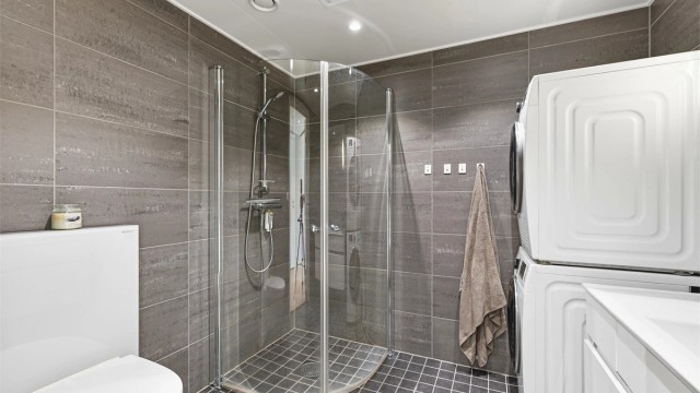 Romslig og moderne bad med plass til både vaskemaskin og tørketrommel. Lun varme i gulvet er behagelig for nakne føtter.