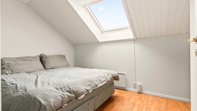 Soverommet på loftet har en lun atmosfære med takvindu som gir godt med dagslys.