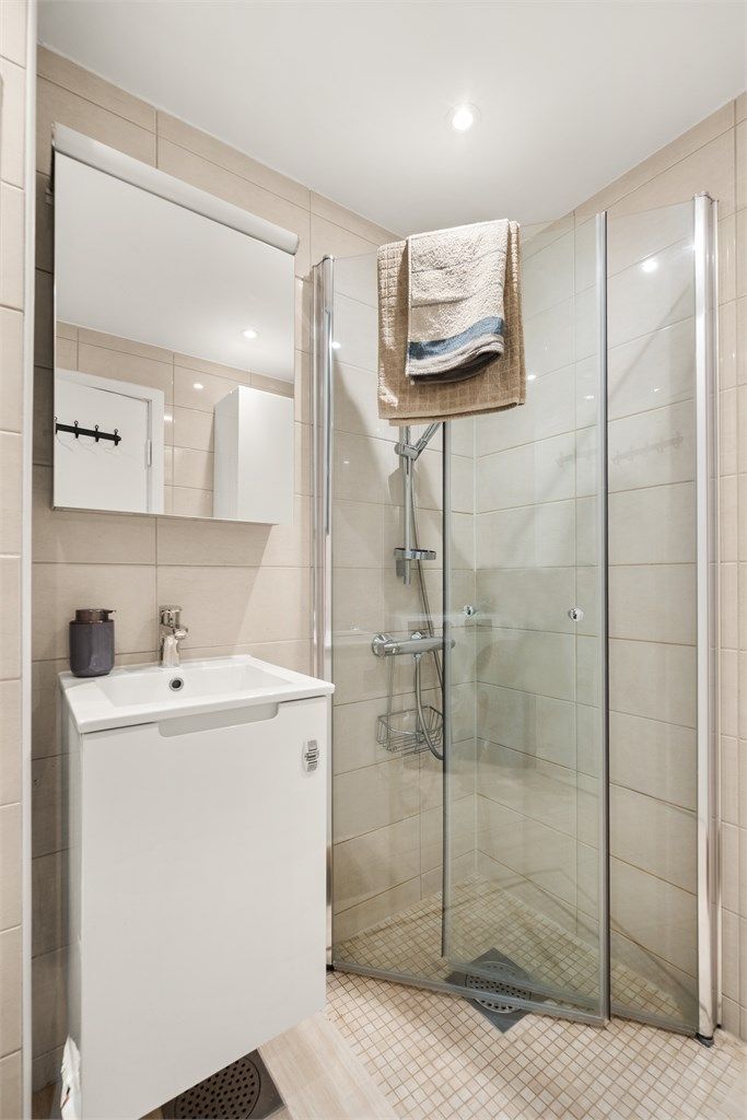 Dusjsonen har innfellbare dører i glass som maksimerer gulvplassen når dusjen ikke er i bruk.