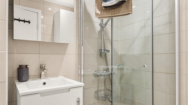 Dusjsonen har innfellbare dører i glass som maksimerer gulvplassen når dusjen ikke er i bruk.