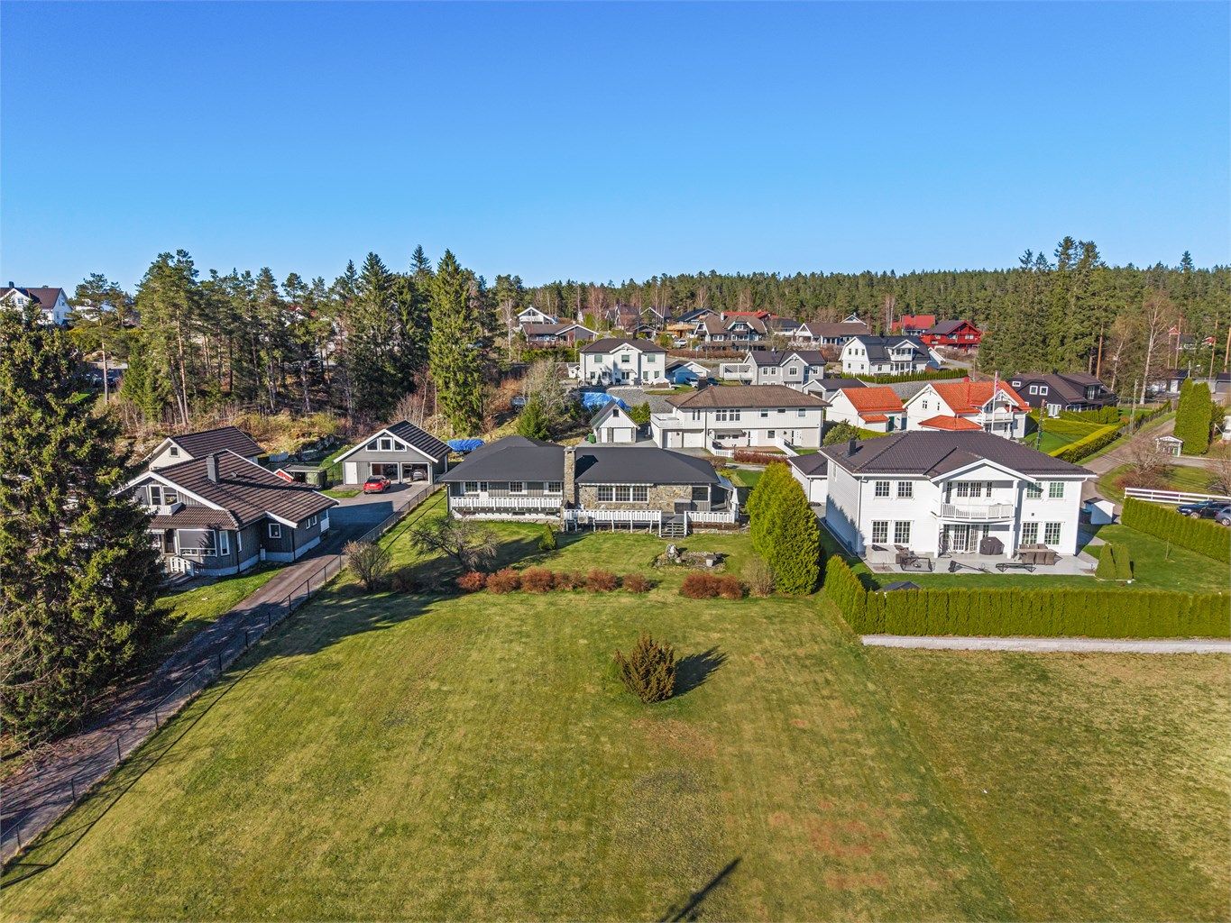 Eiendommen har en stor, flat tomt som gir gode muligheter for lek og utendørsaktiviteter.