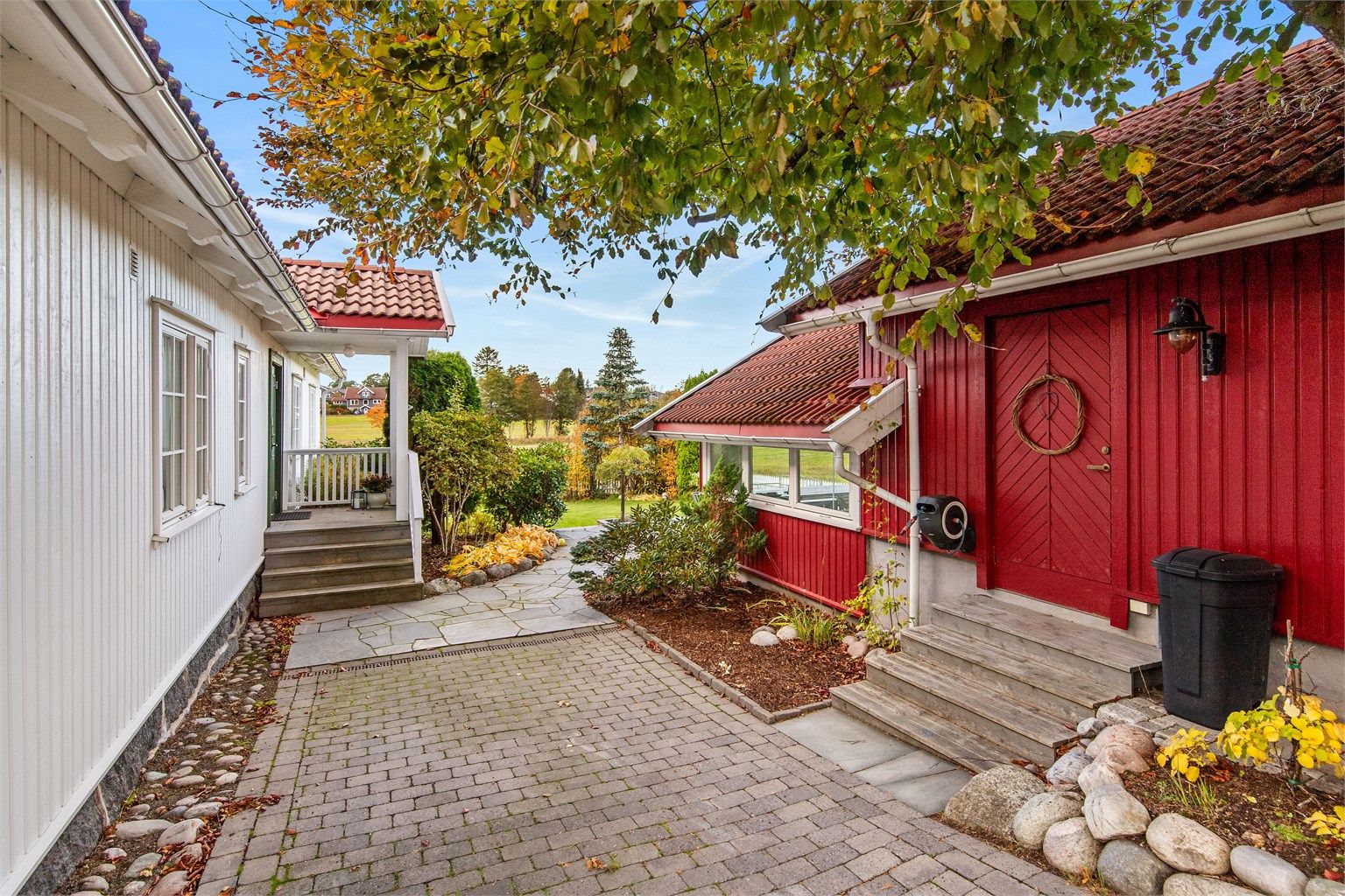 En sjarmerende gangsti mellom hovedhuset og garasjebygget.