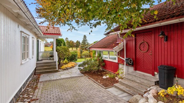En sjarmerende gangsti mellom hovedhuset og garasjebygget.