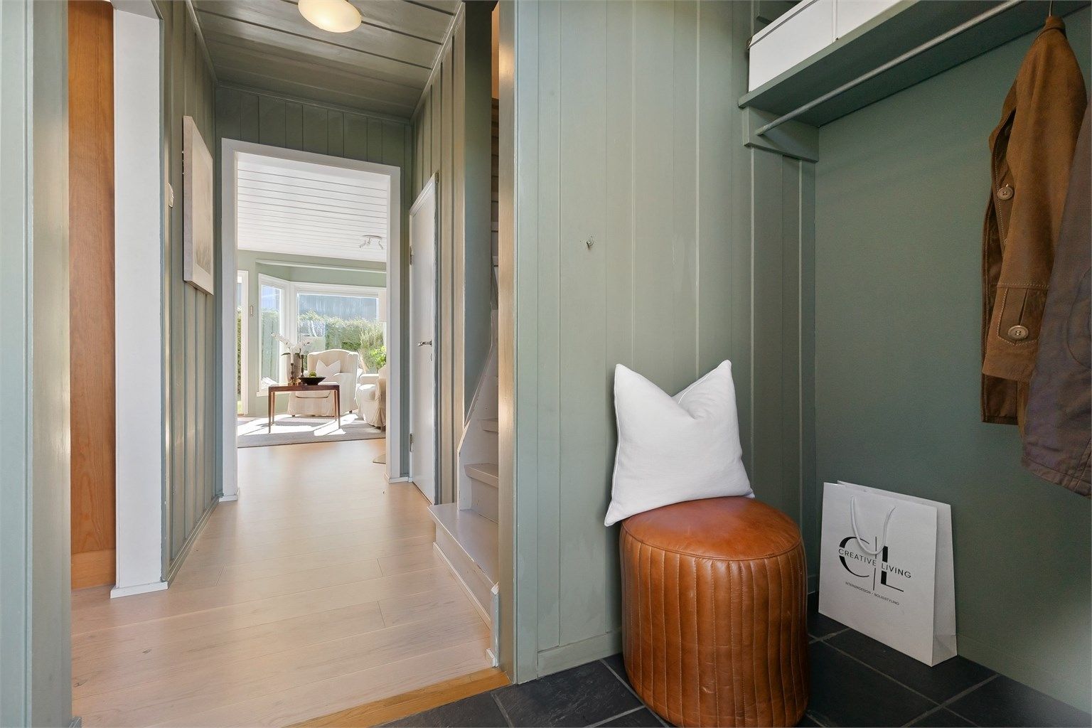 Fra entréen åpner boligen seg opp, med en siktlinje som strekker seg gjennom stuen og ut mot hagen.