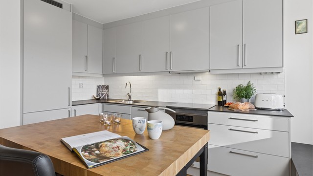 Kjøkkenøyen inviterer til rolige morgenstunder med en kopp kaffe og dagens lesestoff – en hyggelig ramme for både små pauser og gode samtaler.