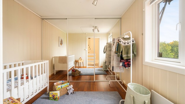 Soverom 2 er et lyst og trivelig soverom med romslig skyvedørsgarderobe, perfekt som barnerom eller gjesterom. (OBS! Gulvet på dette rommet vil bli byttet til overtakelse og fremstå likt som gulvene i resten av boligen).