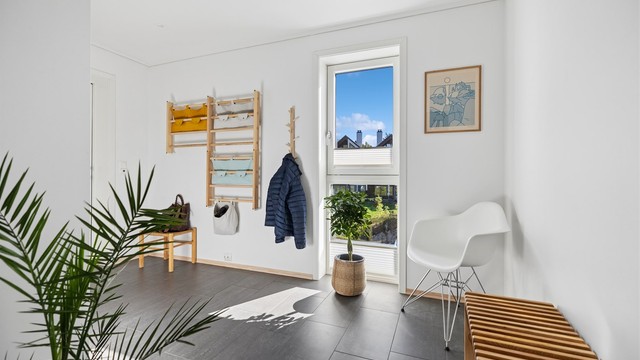 Velkommen inn! Gangen er romslig, det store vinduet slipper inn rikelig med naturlig lys som skaper et lyst og innbydende førsteinntrykk.