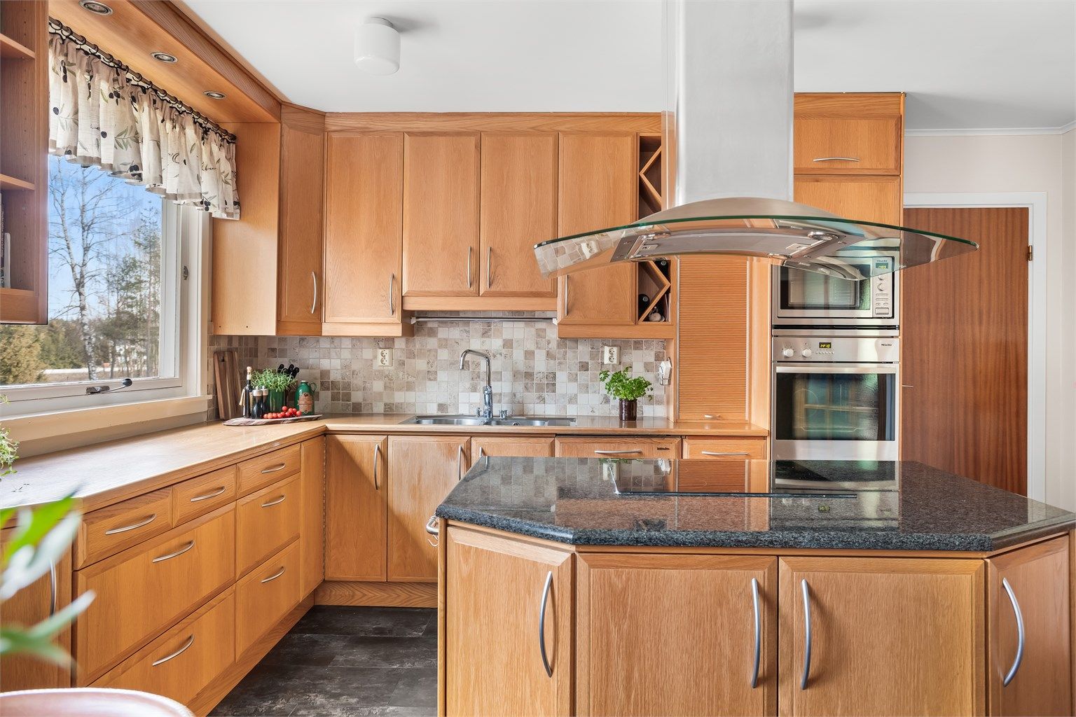 Lys og luftig kjøkken! Her kan du finne blant annet nedfelt induksjonstopp, integrert oppvaskmaskin, benkebelysning og stikkontakter under overskap. 