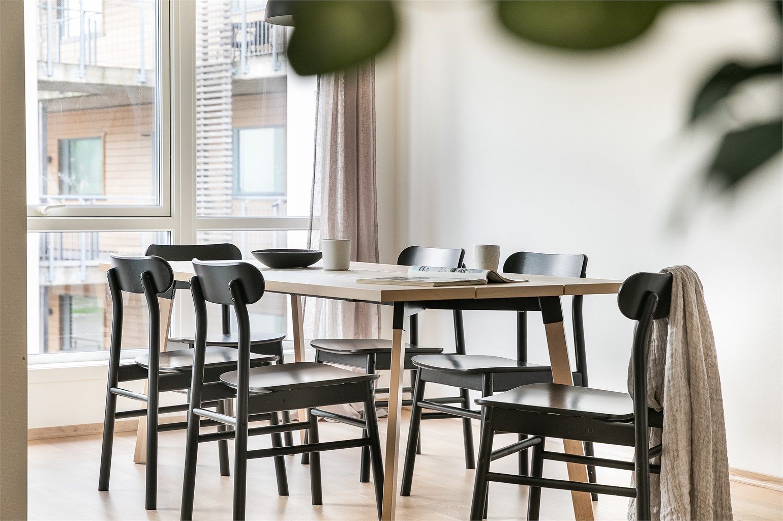 Hjørneform og et romslig areal gjør stuen enkel å møblere med både sofa og spisegruppe.