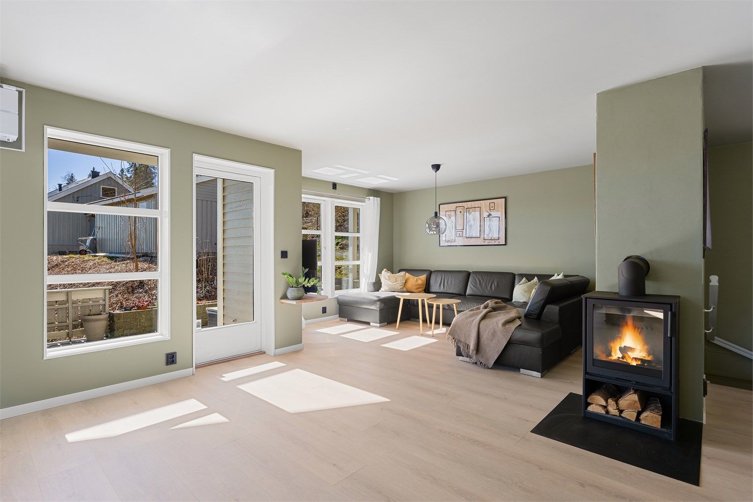 Ildstedet i stuen er sentralt plassert mellom stue- og spisedelen.