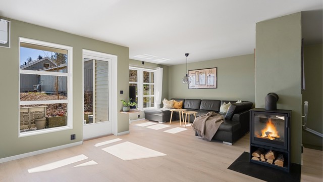 Ildstedet i stuen er sentralt plassert mellom stue- og spisedelen.