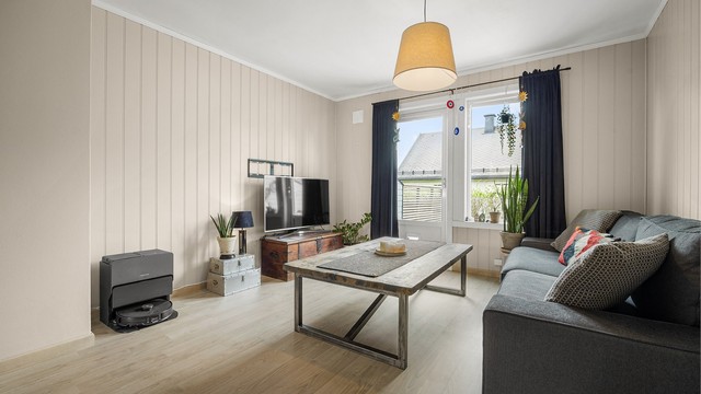 Åpen kjøkken- og stueløsning med sofaområde.