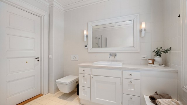 Også dette badet har vannbåren gulvvarme og en stilren servantinnredning med nedfelt porselensservant