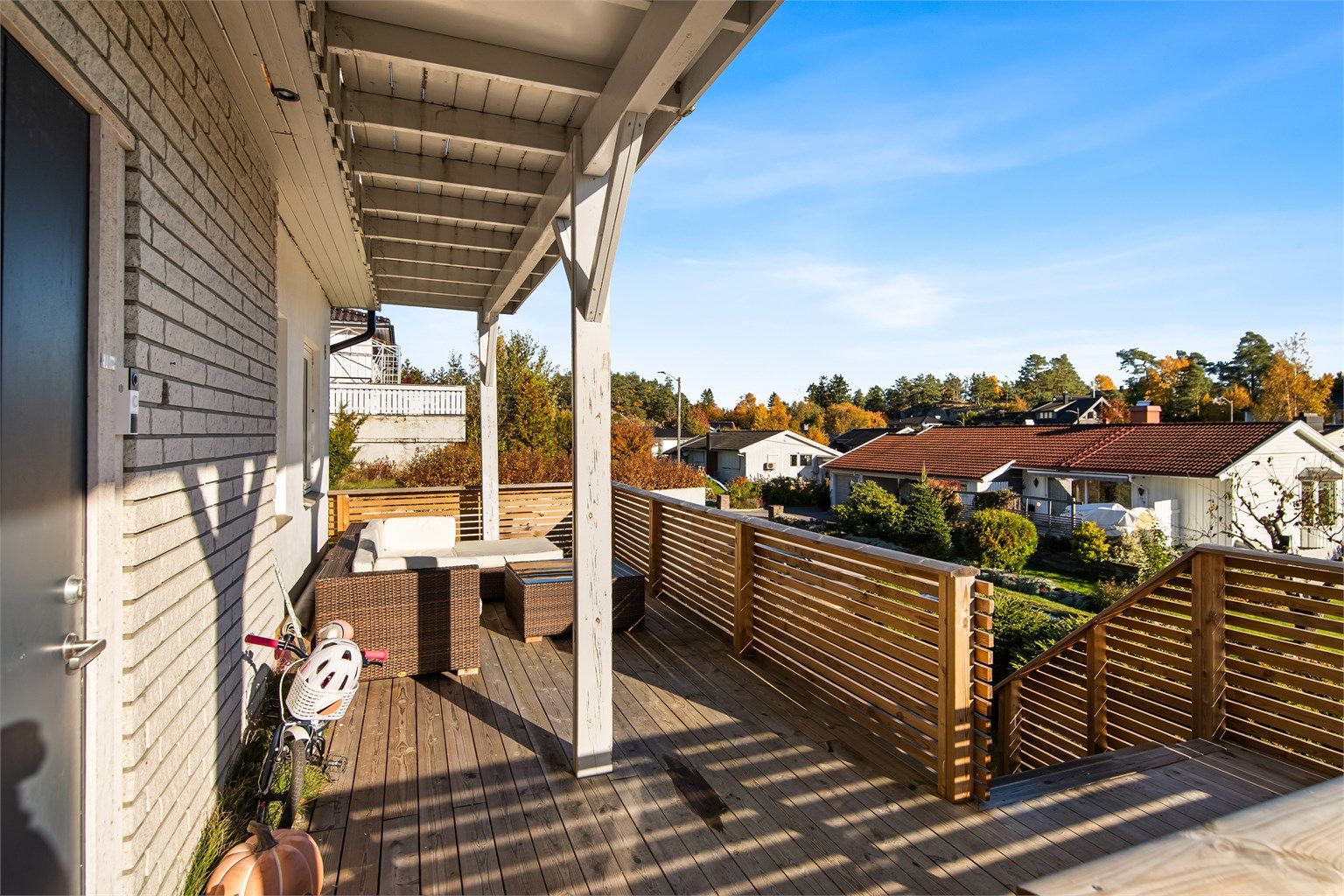 Overbygd terrasse i trekonstruksjon ved inngangspartiet i underetasjen.