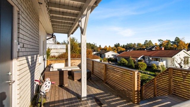 Overbygd terrasse i trekonstruksjon ved inngangspartiet i underetasjen.
