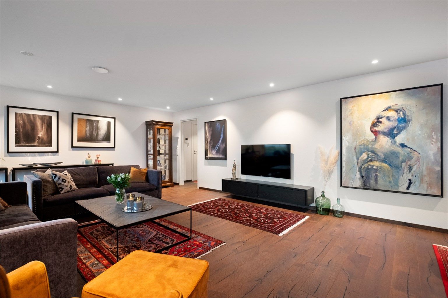 Stuen har lyse overflater på vegger og tak med dels innfelt spottbelysning 