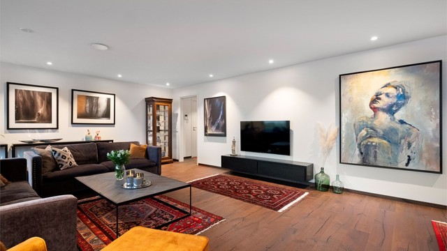 Stuen har lyse overflater på vegger og tak med dels innfelt spottbelysning