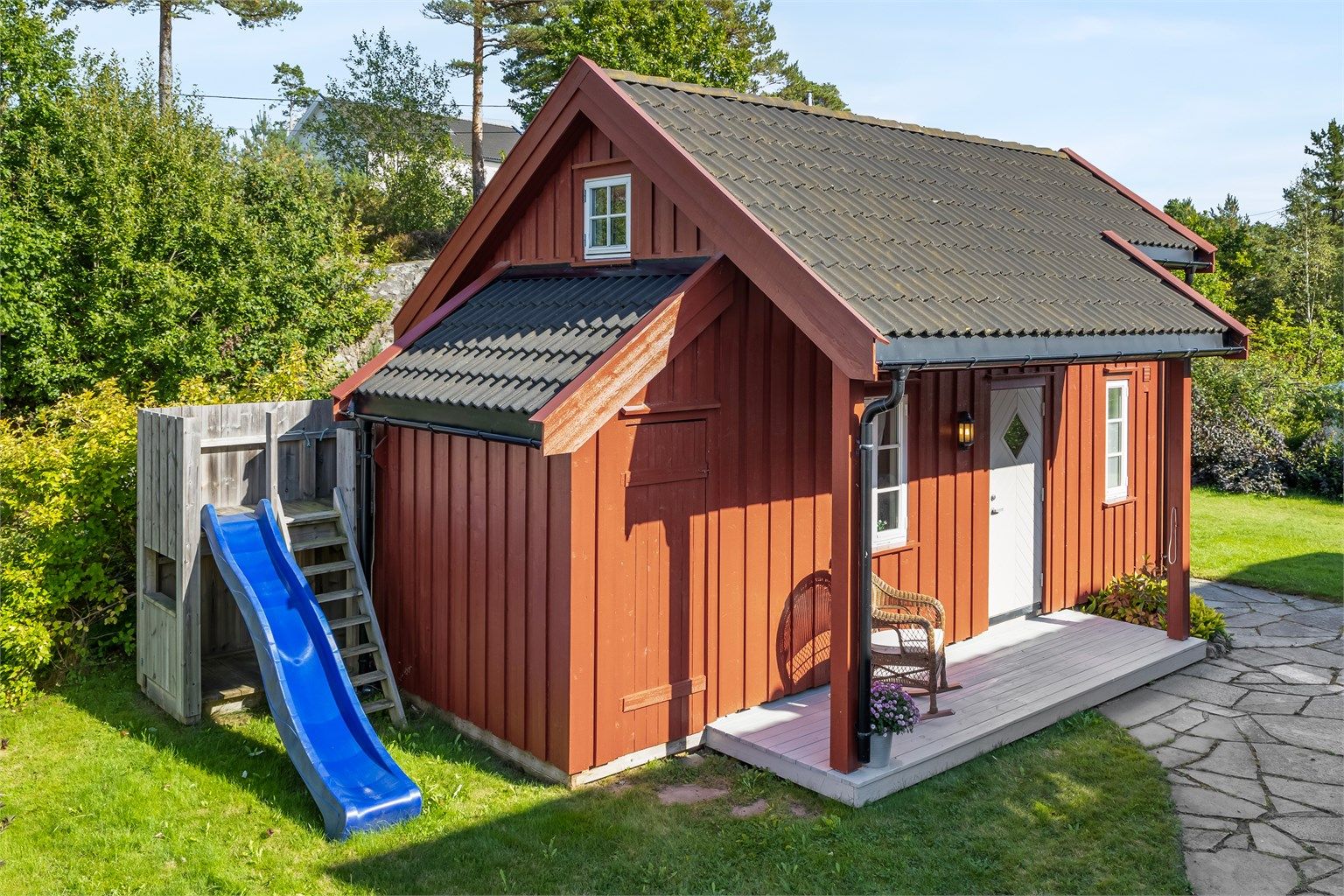 Barnevennlig og fin tomt utstyrt med lekeapparater. Praktisk anneks innredet med soverom/stue med kjøkkenkrok, hems og bad