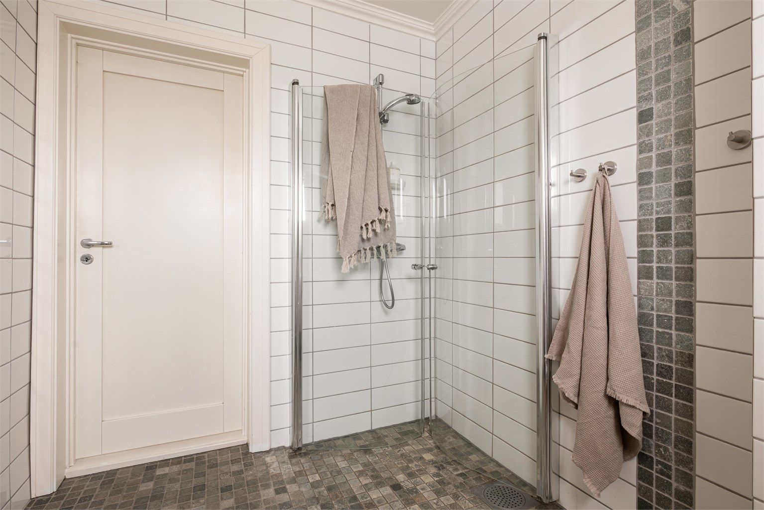 Praktisk dusjhjørne med svingbare glassdører. Badet har gulvvarme