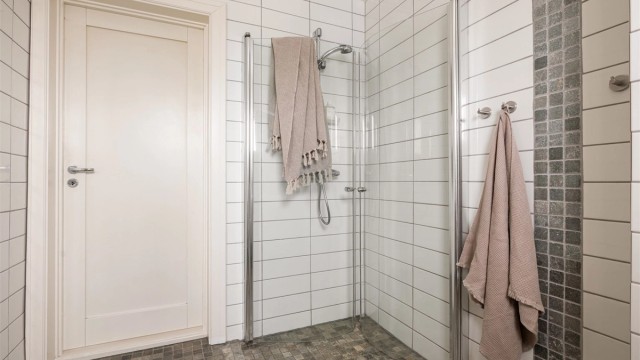 Praktisk dusjhjørne med svingbare glassdører. Badet har gulvvarme