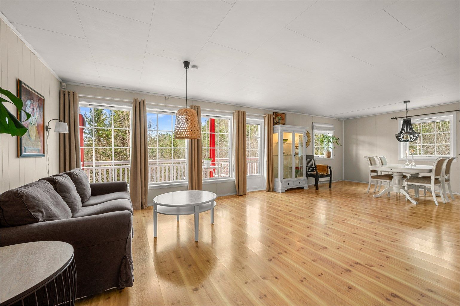 Lys og romslig stue med god plass til flere møbleringssoner og store vindusflater som slipper inn rikelig med dagslys.