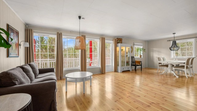 Lys og romslig stue med god plass til flere møbleringssoner og store vindusflater som slipper inn rikelig med dagslys.