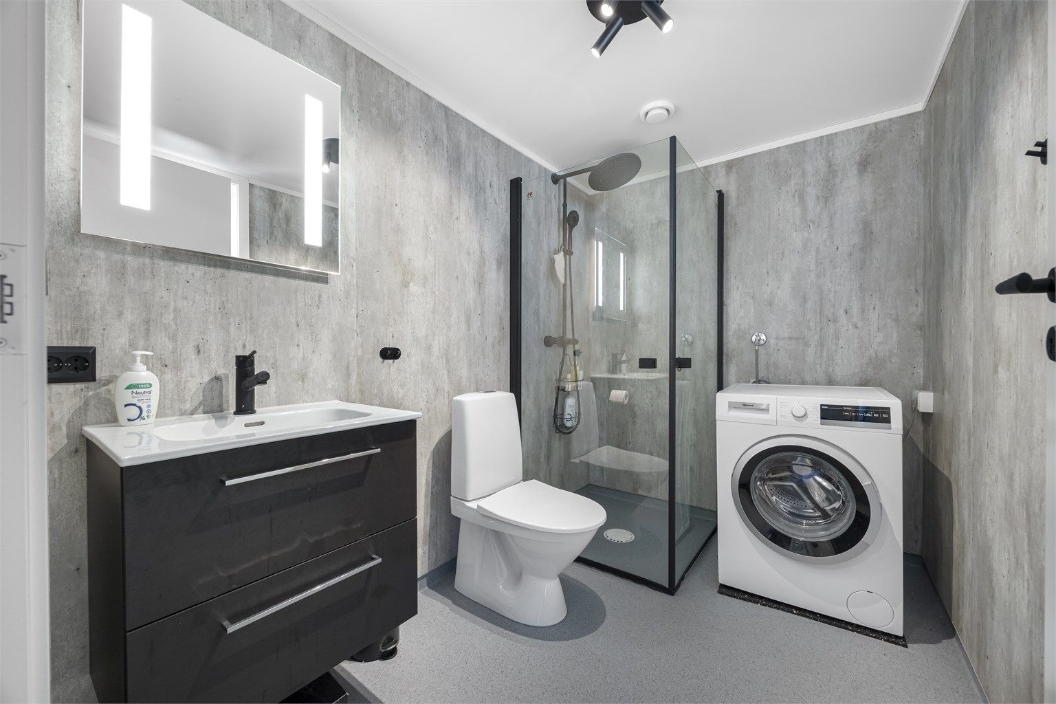 Badet har elektriske varmekabler i gulvet, baderomsplater på veggene og opplegg for vaskemaskin.