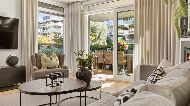 Skyvedørene i glass visker ut skillet mellom stuen og den store terrassen utenfor