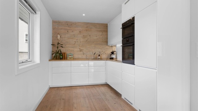 Pent kjøkken med IKEA innredning fra 2018. Innredning med glatte fronter. Benkeplate av tre med nedfelt oppvaskkum.