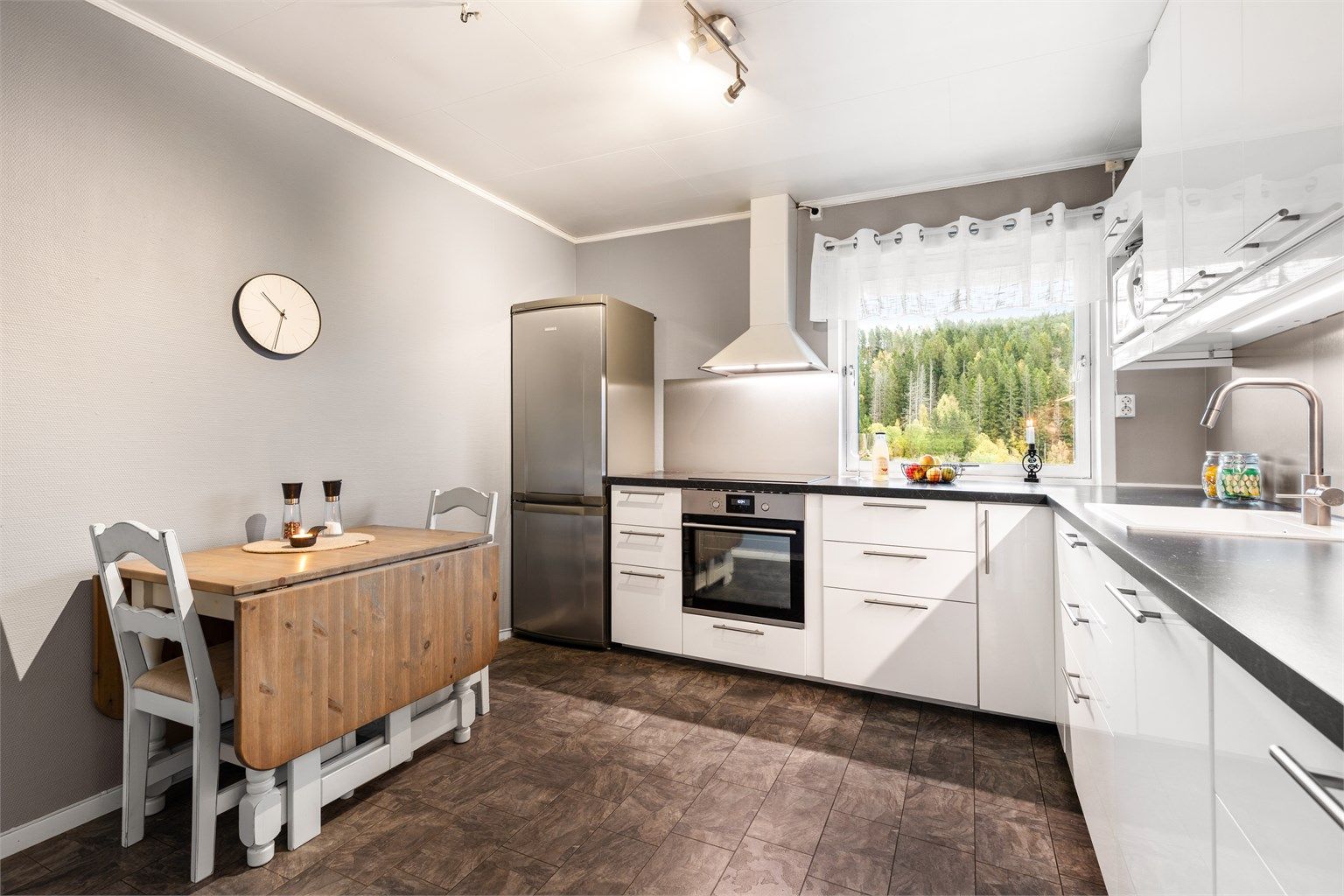 Det er frittstående kjøleskap med fryser og vegghengt ventilator, samt integrert stekeovn, platetopp og oppvaskmaskin. Det er også laminert plate mellom kjøkkenbenk og overskap. 