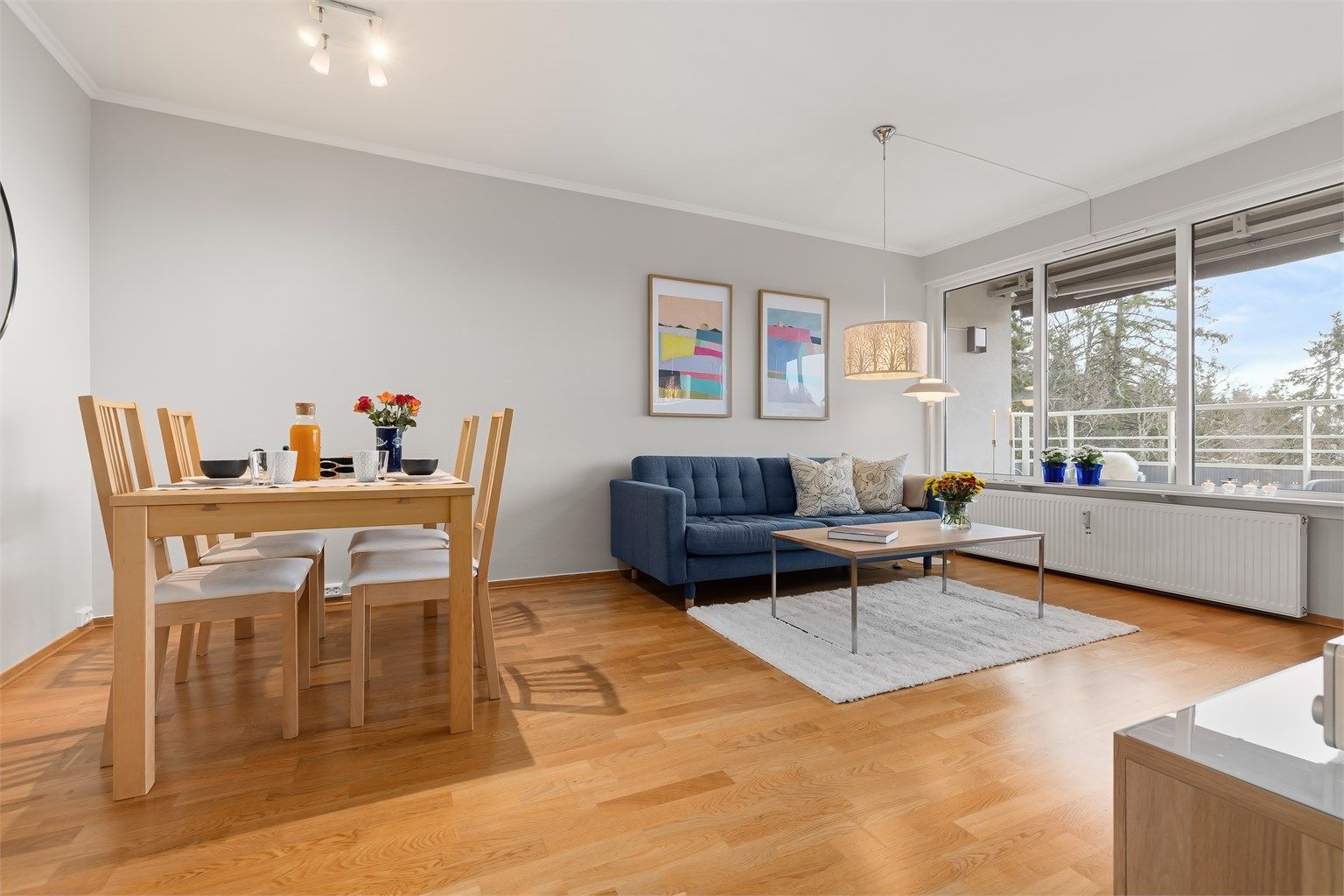 Tiltalende og moderne stue med parkettgulv, store vindusflater og en fri utsikt, noe som gir en flott atmosfære