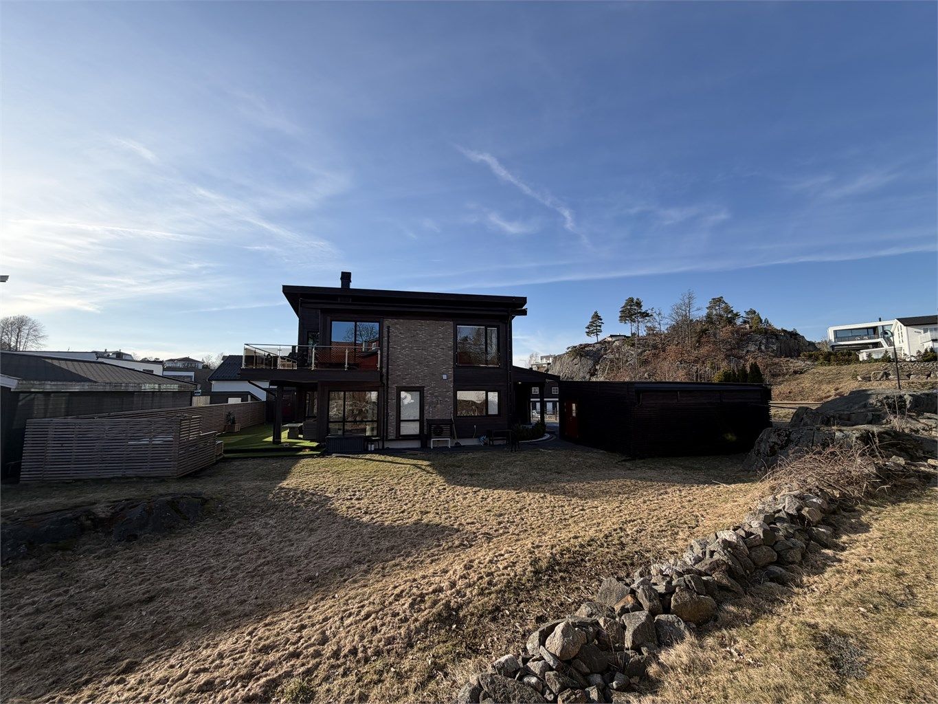 Boligen har flere uteplasser og en praktisk, overbygget inngang på baksiden.