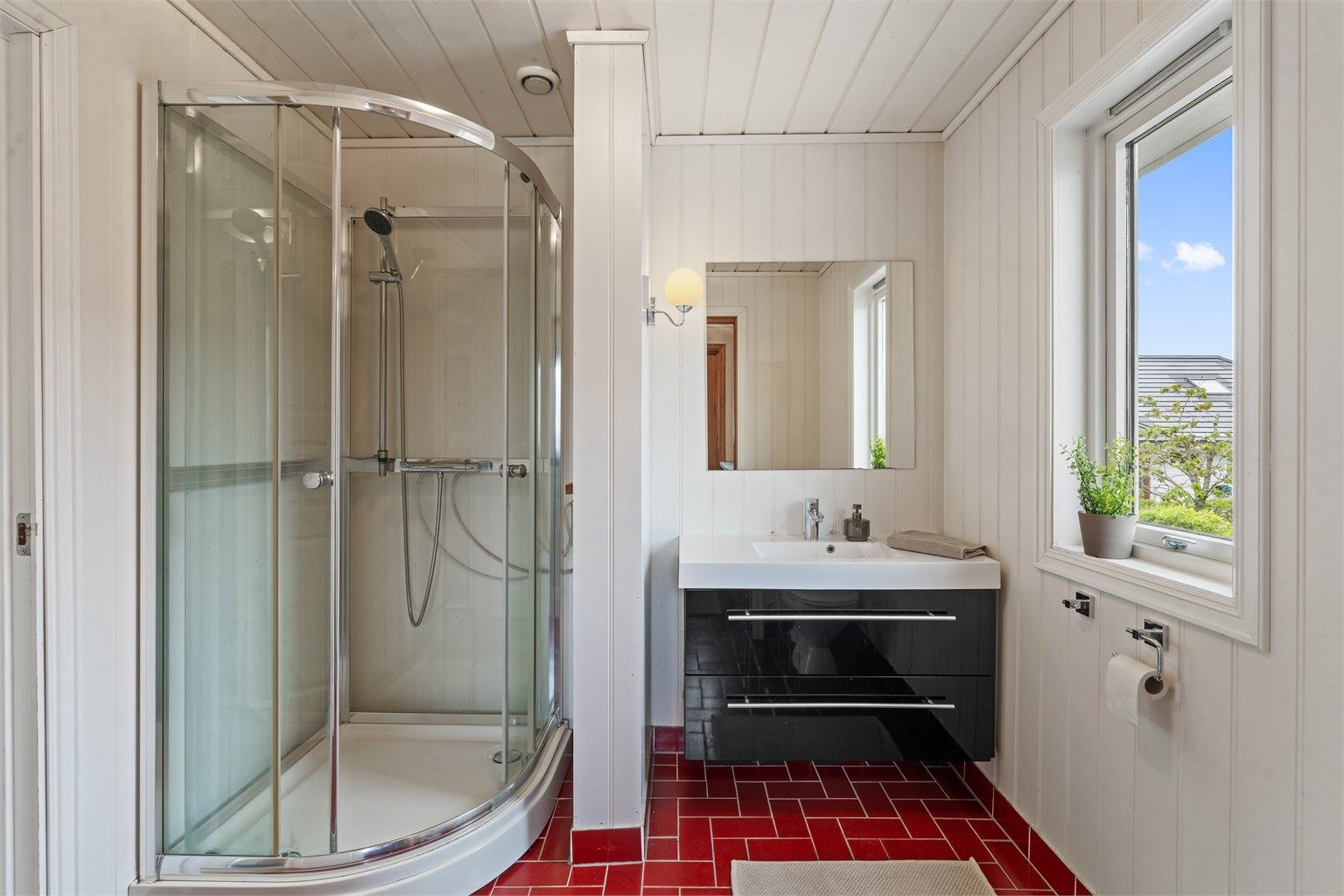 Badet er innredet med vegghengt servantinnredning med skuffer.