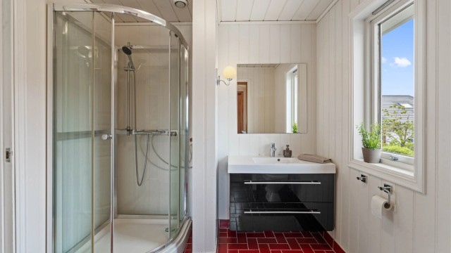 Badet er innredet med vegghengt servantinnredning med skuffer.