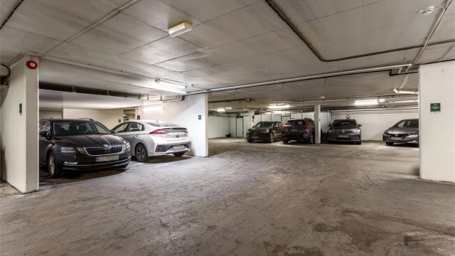 Leiligheten disponerer en parkeringsplass i felles garasjekjeller. Leiligheten har ikke installert ladestasjon, men borettslaget har tilrettelagt for etablering av ladestasjoner for el-bil i garasjeanlegget.
