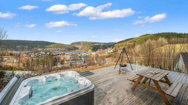 Romslig terrasse med god plass til utemøbler og sosiale sammenkomster, samt bålpanne som skaper en lun og hyggelig stemning.