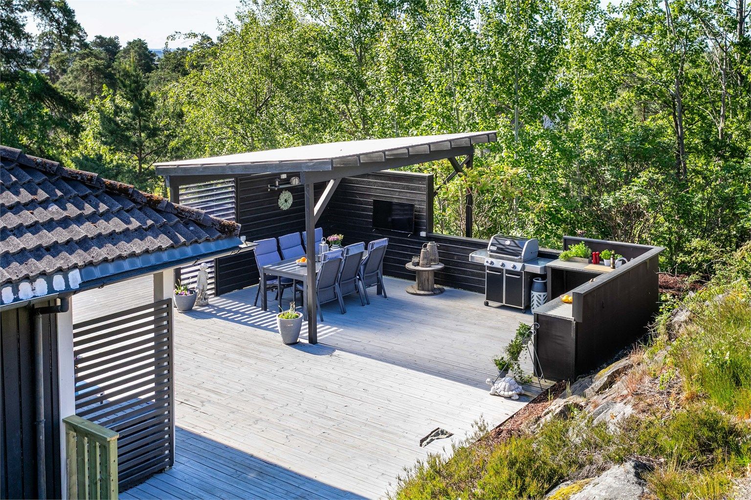 Et flott uterom med både kjøkken og pergola med tett tak er anlagt på terrassen i senere år.