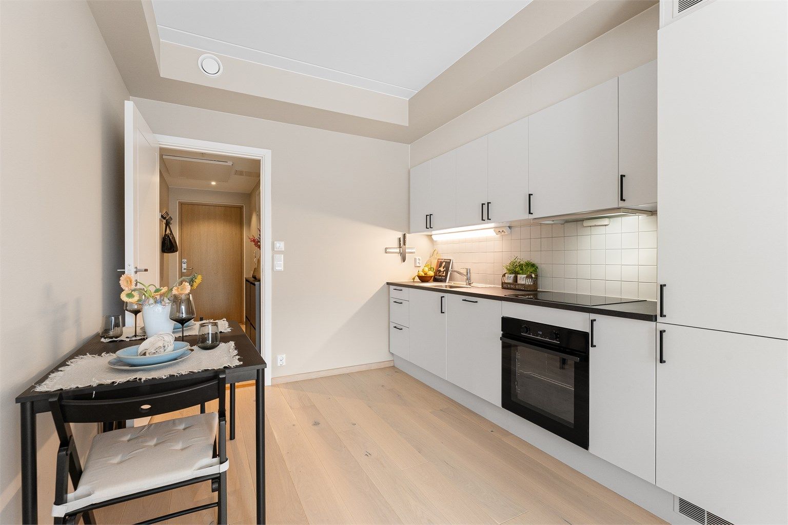 Kjøkkeninnredningen fra Designa har glatte fronter og en slitesterk laminatbenkeplate.