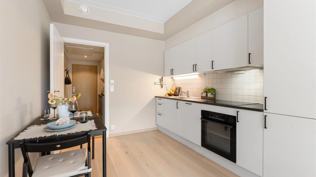 Kjøkkeninnredningen fra Designa har glatte fronter og en slitesterk laminatbenkeplate.