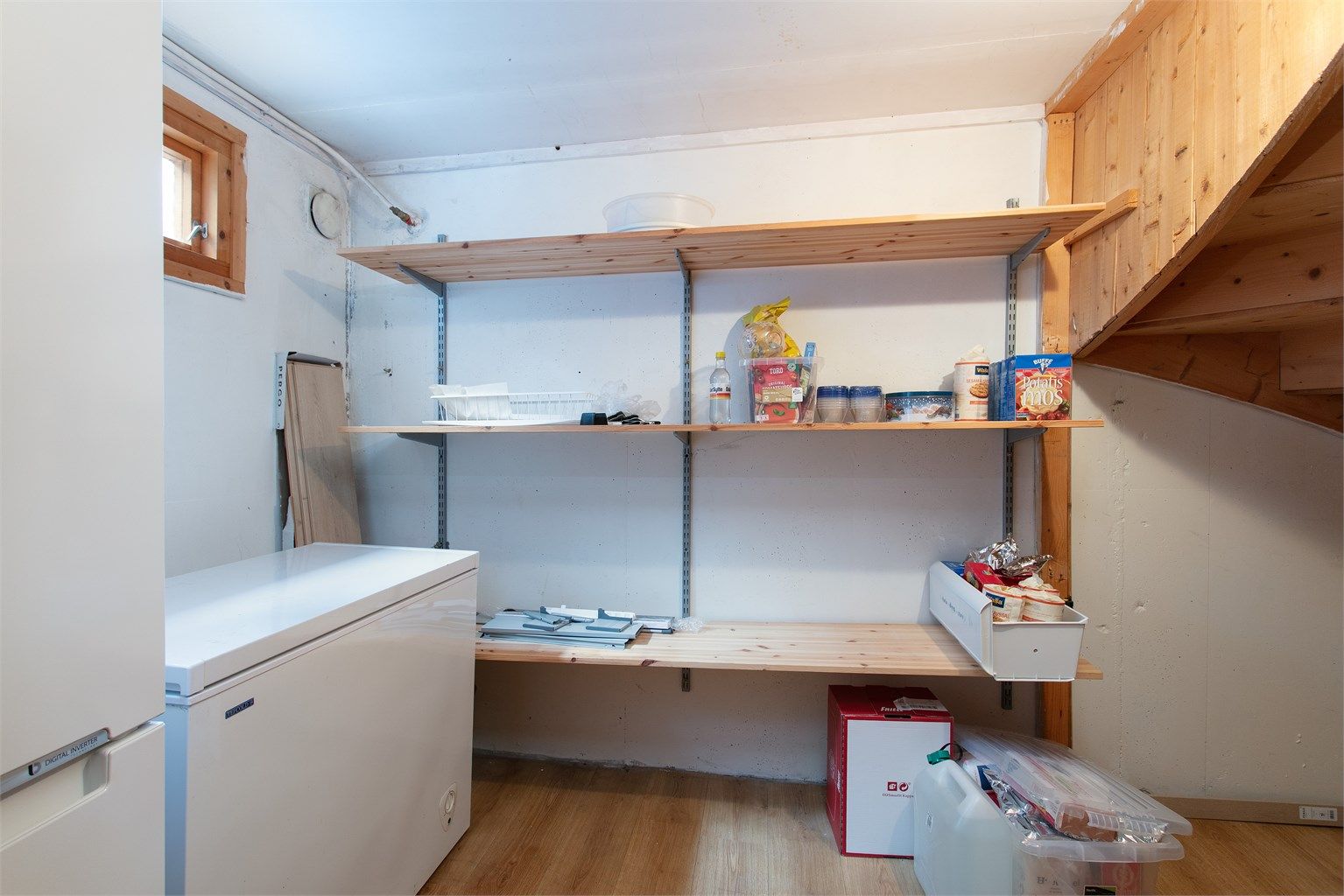 Romslig bod i kjelleren med fastmonterte oppbevaringshyller.
