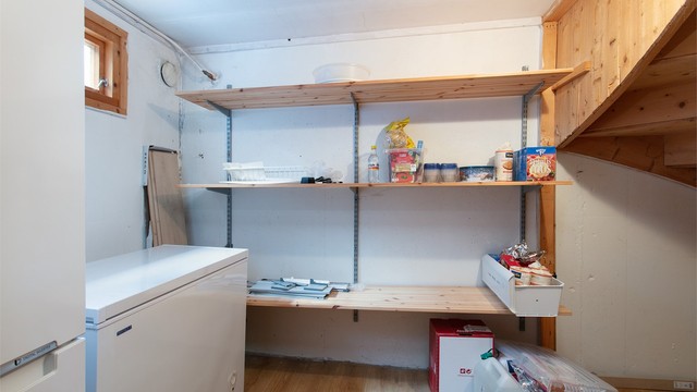 Romslig bod i kjelleren med fastmonterte oppbevaringshyller.