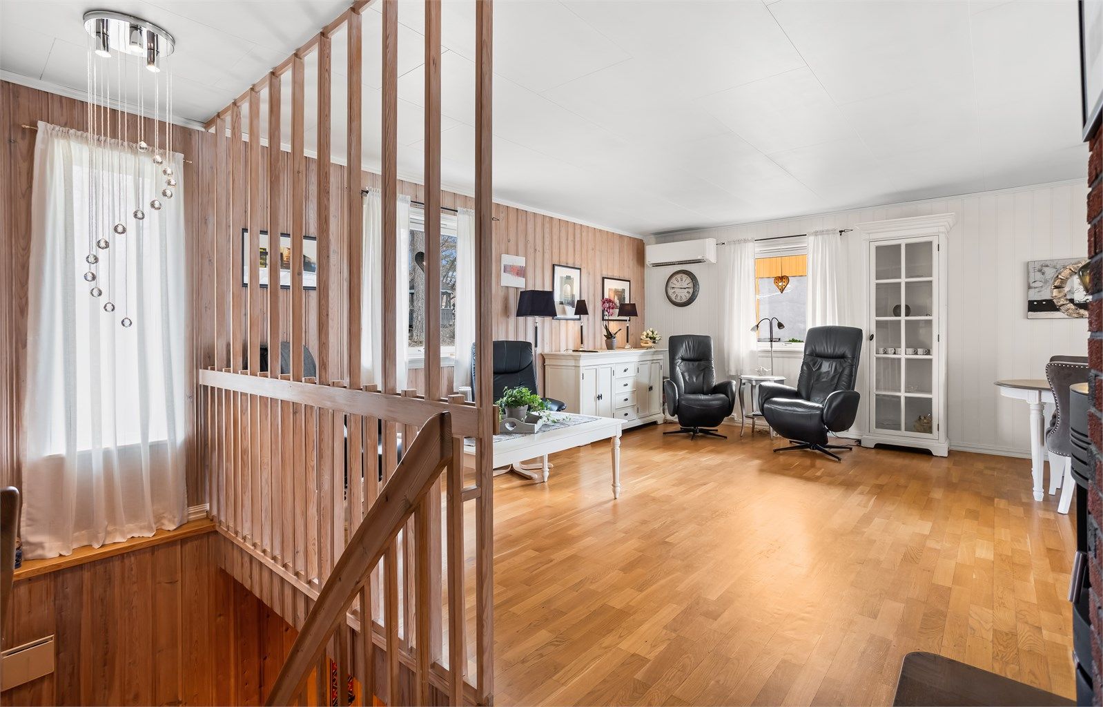 Stuen i første etasje har parkett på gulvet og plass til flere sittegrupper.