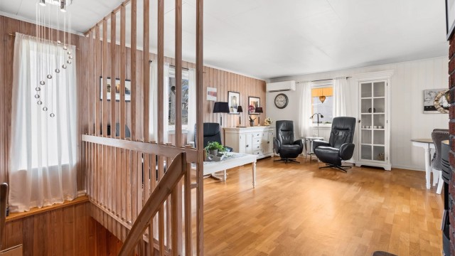 Stuen i første etasje har parkett på gulvet og plass til flere sittegrupper.