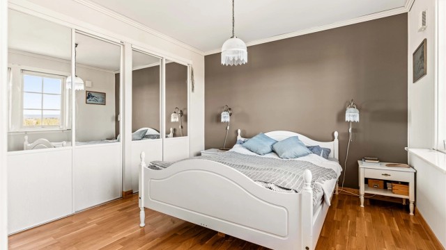 Soverommet i første etasje har rikelig med oppbevaringsplass i en stor skyvedørsgarderobe.
