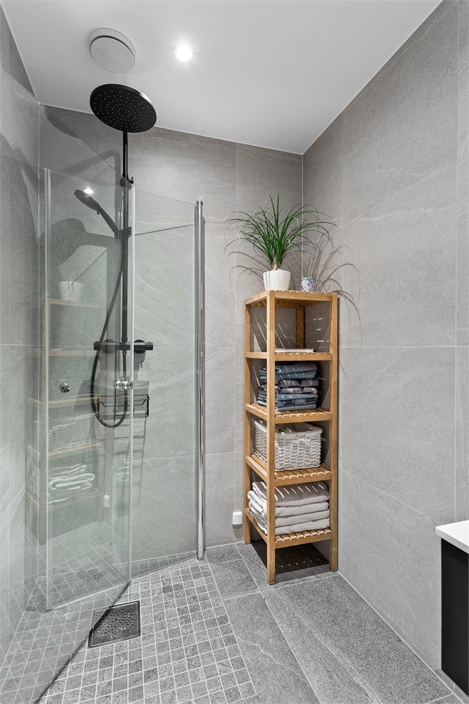 Bad 1 med dusjhjørne med glassdører og vegghengt toalett