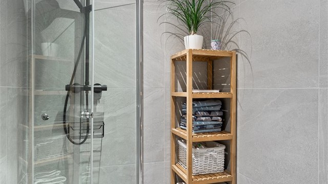 Bad 1 med dusjhjørne med glassdører og vegghengt toalett