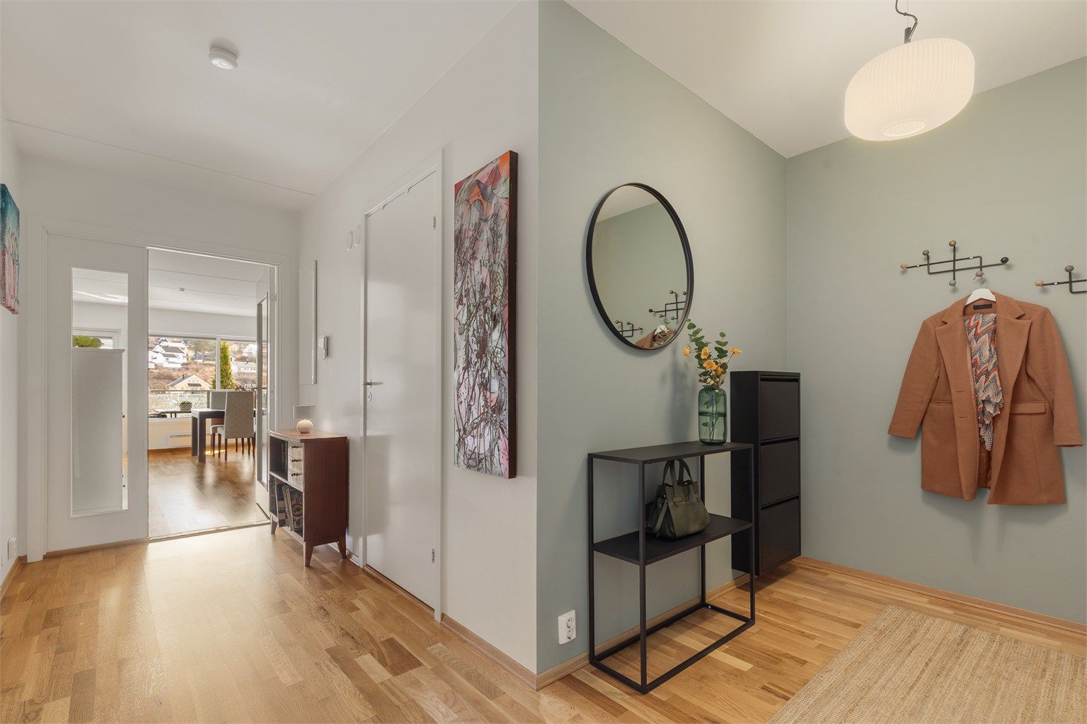 Romslig gang med dør som skiller to av soverommene og bad fra stue/kjøkken