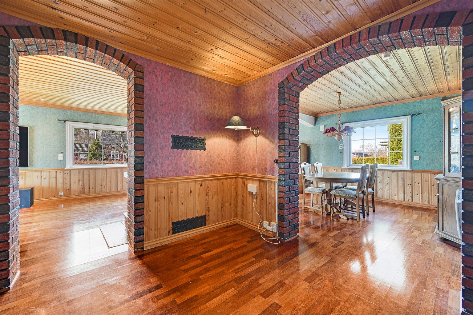 Mursteinsdetaljer og bueganger skaper en sjarmerende overgang mellom stue og spisestue.