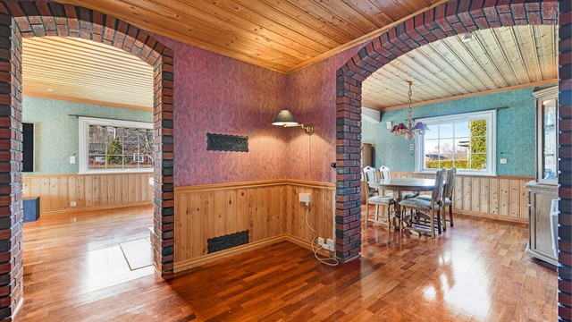 Mursteinsdetaljer og bueganger skaper en sjarmerende overgang mellom stue og spisestue.