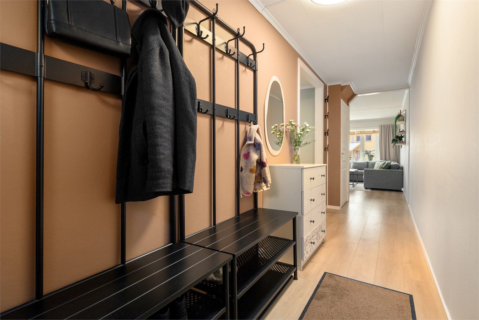 Boligen har en innbydende og praktisk entré med god plass til oppheng for ytterklær, benker og kommode.